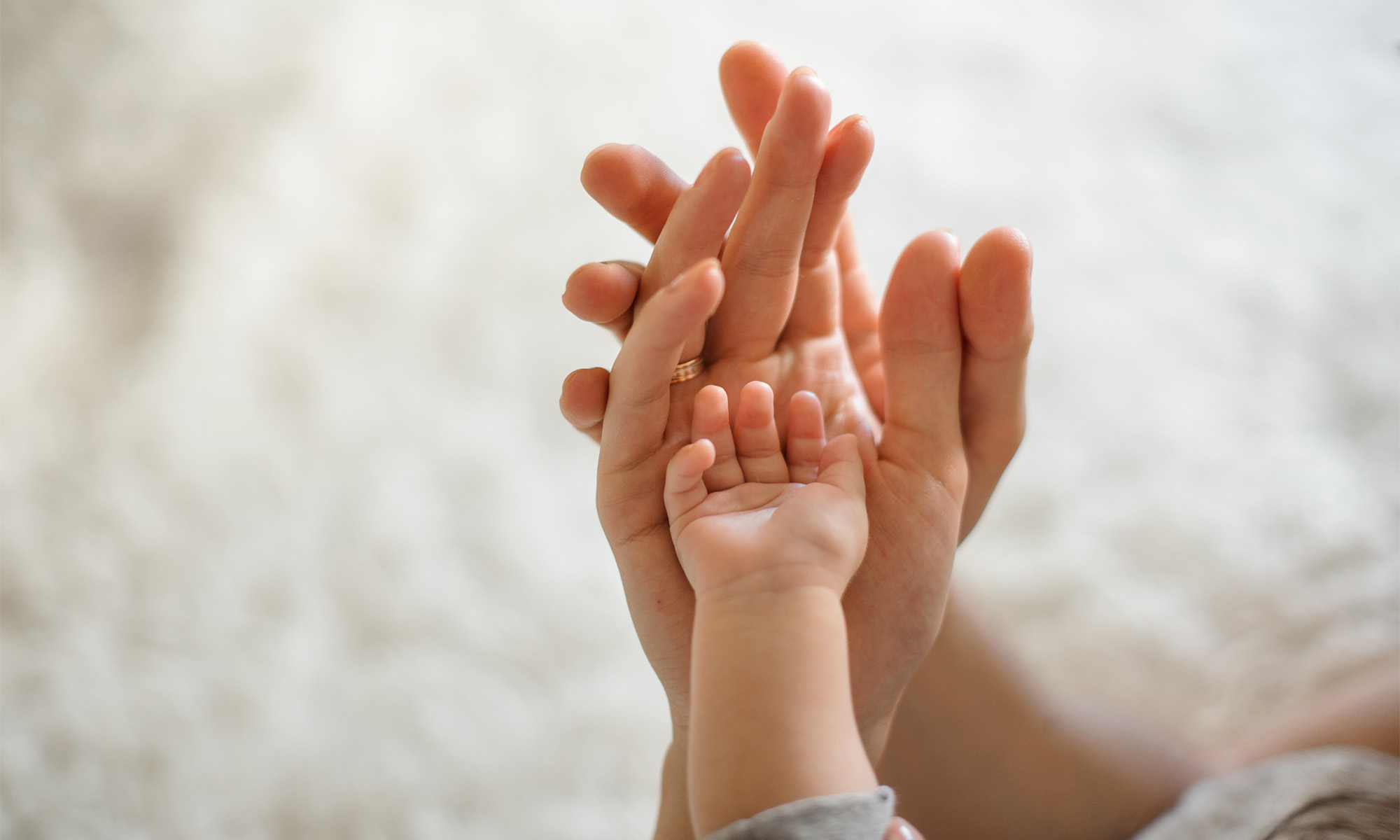 Hände halten Babyhand SRS Jahresbericht 2022 Stiftung SeeYou Hamburg